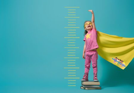 little girl wearing a cape and mask stepping on text books next to a growth chart